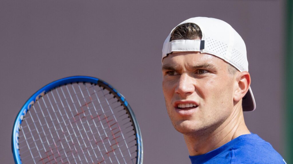 Jack Draper celebrates his first Roland Garros win after a comeback against Mattia Bellucci in a four-set match.